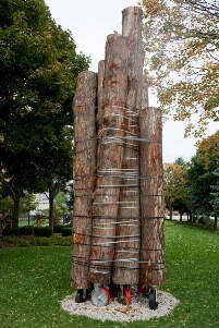 Sculpture made of strapped together logs.